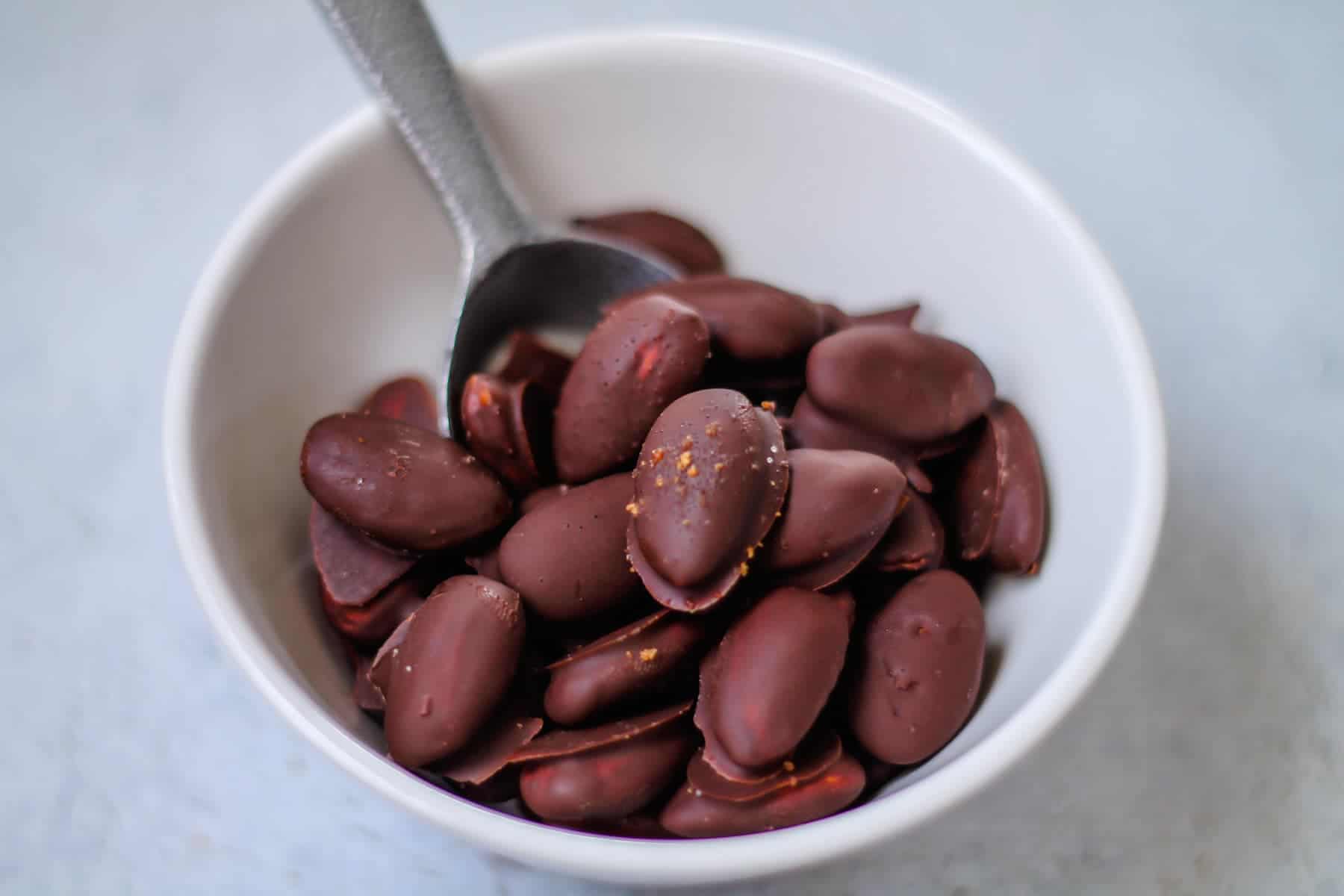 A bowl of chocolate covered almonds.