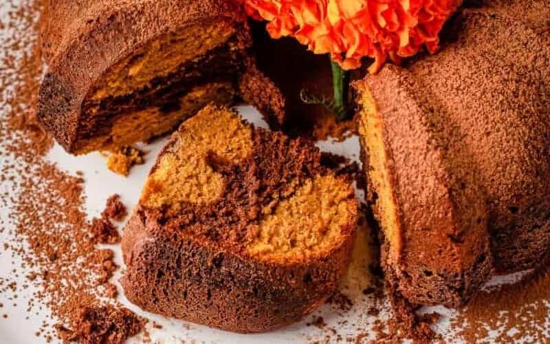 Chocolate Pumpkin Cake on a platter with a slice cut out.