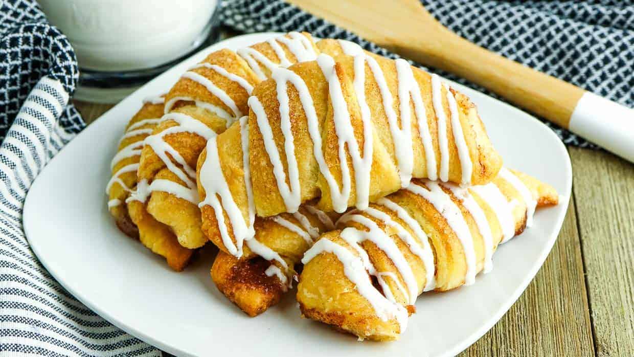 Crescent rolls with cinnamon sugar and icing on a plate.