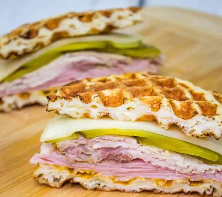 Two Cuban Chaffle sandwiches on a cutting board.