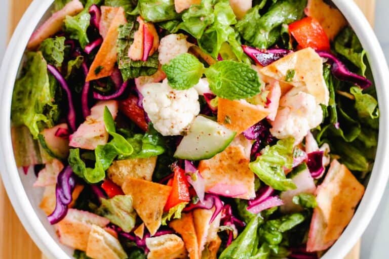 A white bowl with a salad in it.