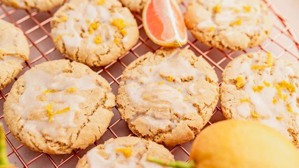 Lemon cookies with icing on a cooling rack.
