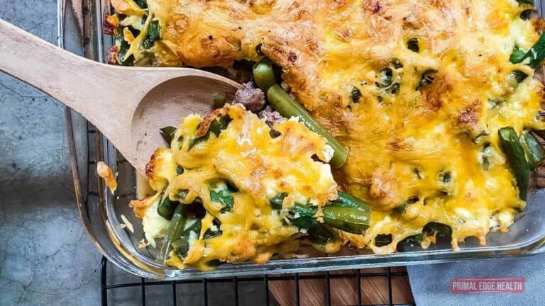 A casserole dish filled with green beans and cheese.