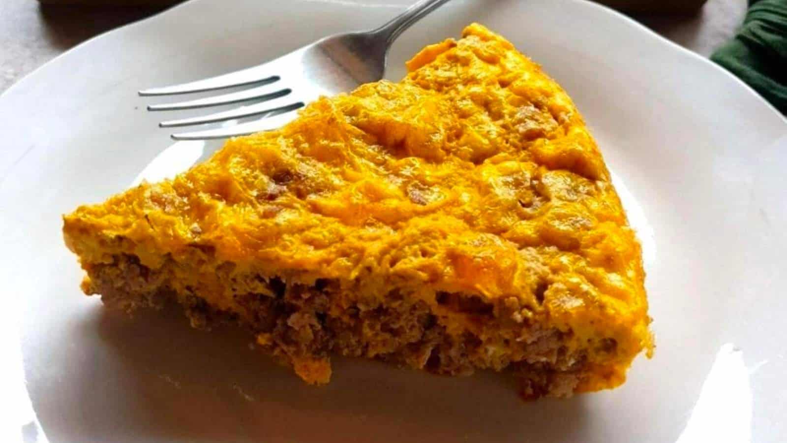 A person cutting a piece out of a casserole.