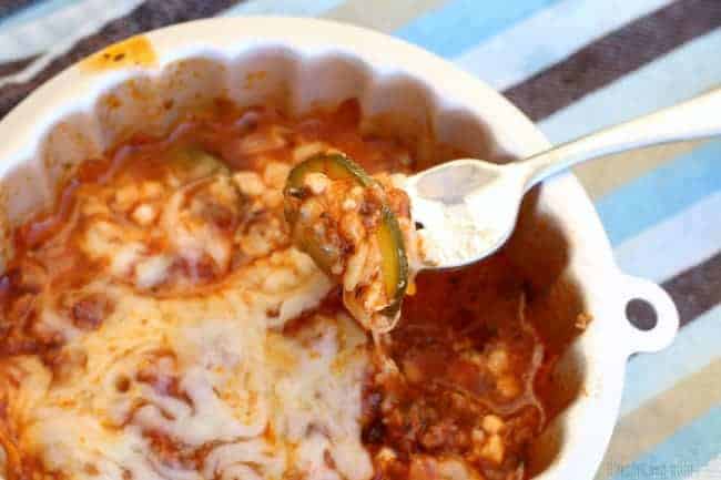 Dish of zucchini lasagna with a fork full of lasagna in the foreground.