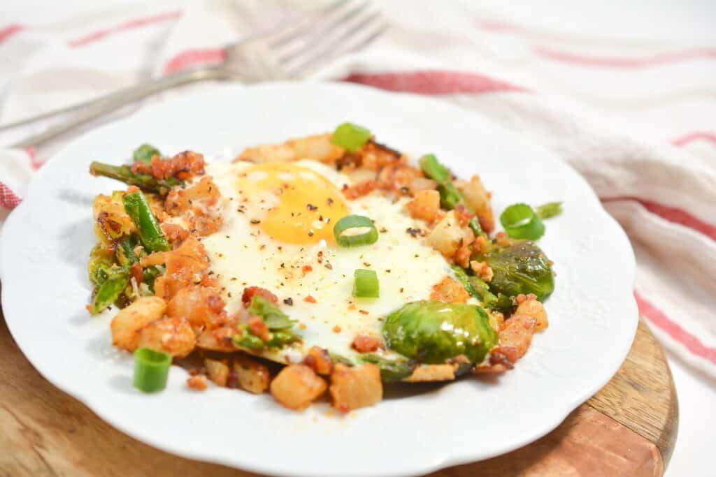 A plate with a fried egg and vegetables on it.