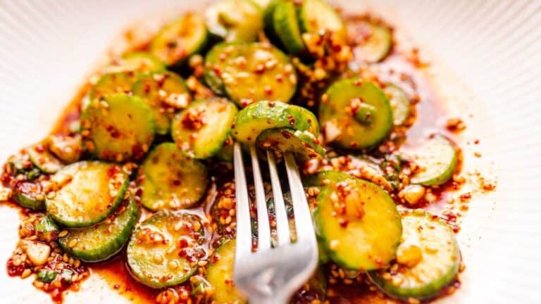 An easy recipe for a plate of cucumbers with a fork on it.