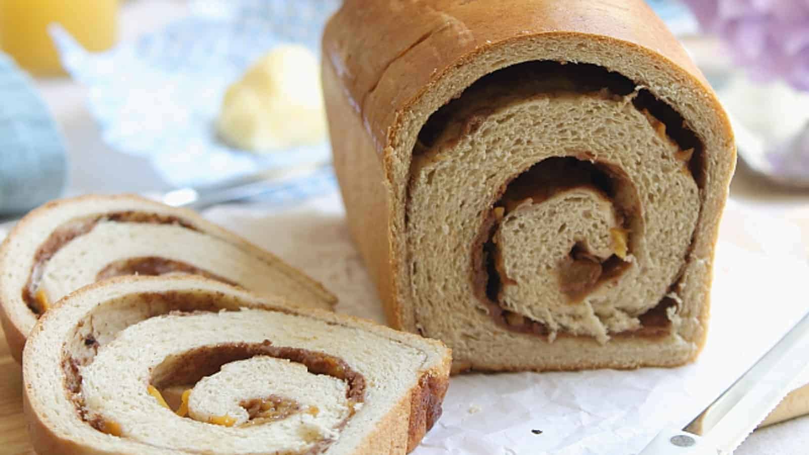 Loaf of roasted peach cinnamon swirl bread with two slices cut off.