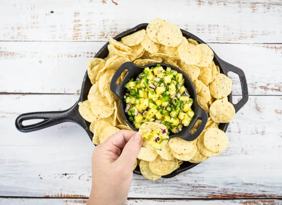 Pineapple salsa in a skillet with tortilla chips.