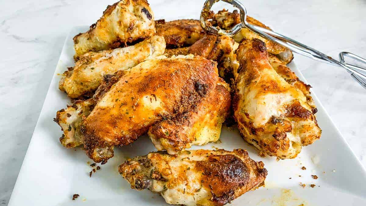 Plate of air fryer ranch wings with tongs in the background.