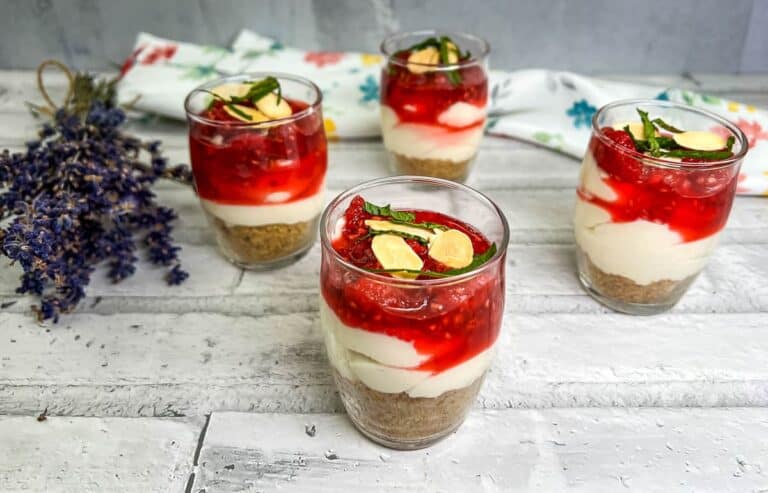 Four glasses of raspberry cheesecake parfait.