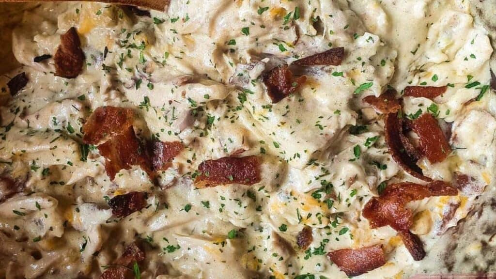 A casserole dish with bacon and cheese in it.