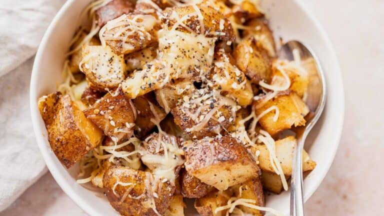 A slow cooker recipe for a bowl of roasted potatoes with cheese and parmesan.