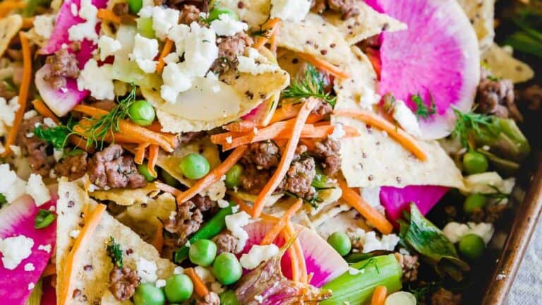 Nachos with meat and vegetables in a baking dish.