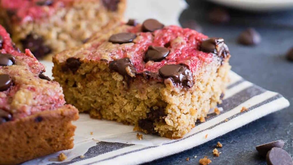 A slice of chocolate raspberry oatmeal bars on a napkin.