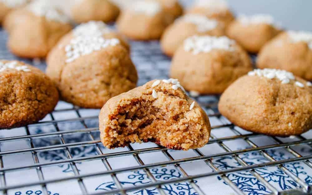 A batch of tahini cookies cooling on a wire rack.