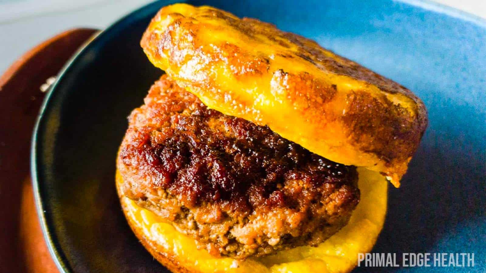 A hamburger patty is sitting on a plate.