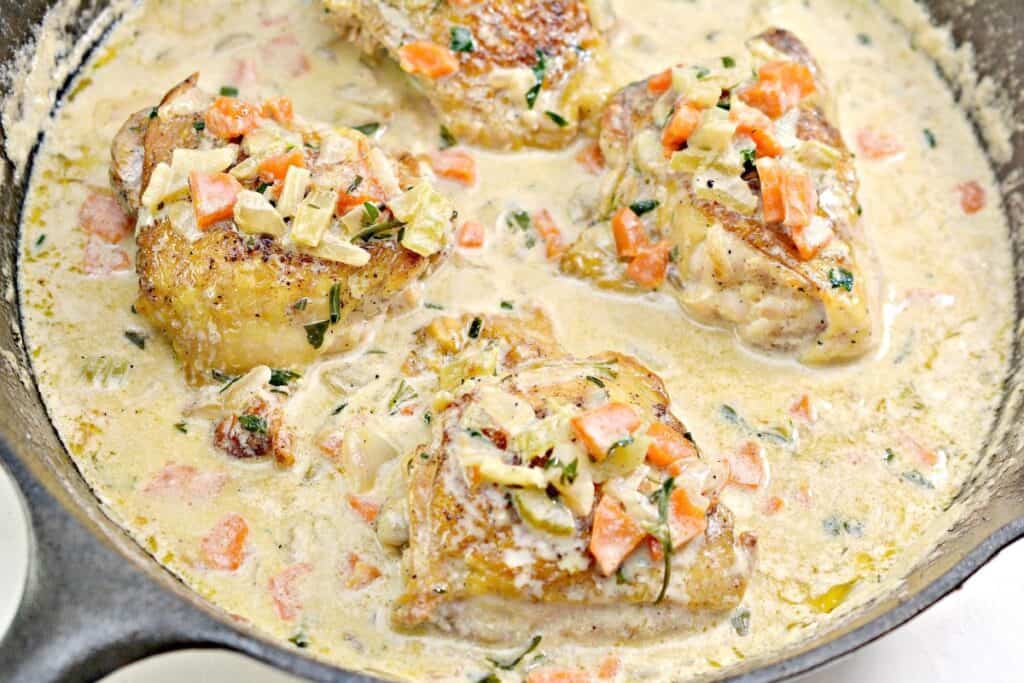 Chicken dinners with chicken breasts cooked in a skillet and served with a delicious cream sauce, paired with tender carrots.