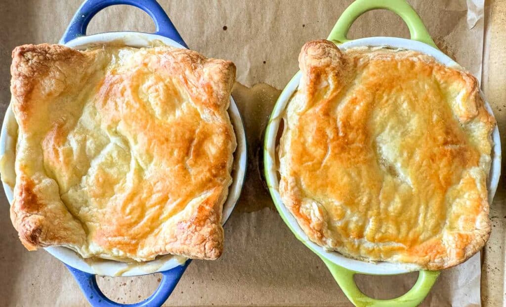 Two pot pies in a green and blue bowl.