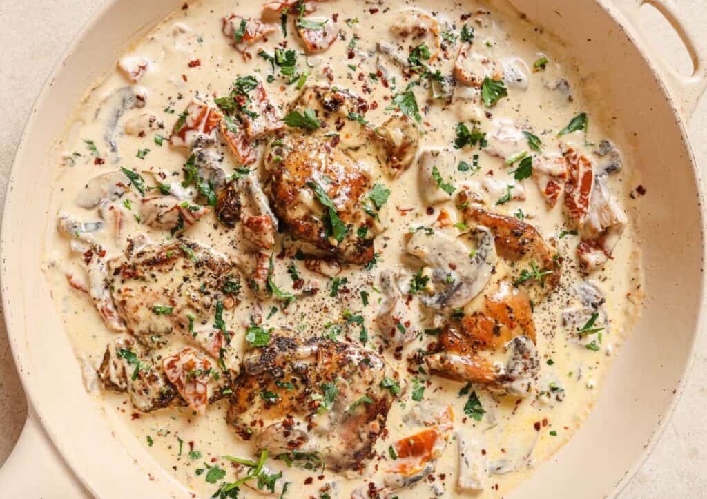 A pan with chicken in a creamy sauce.