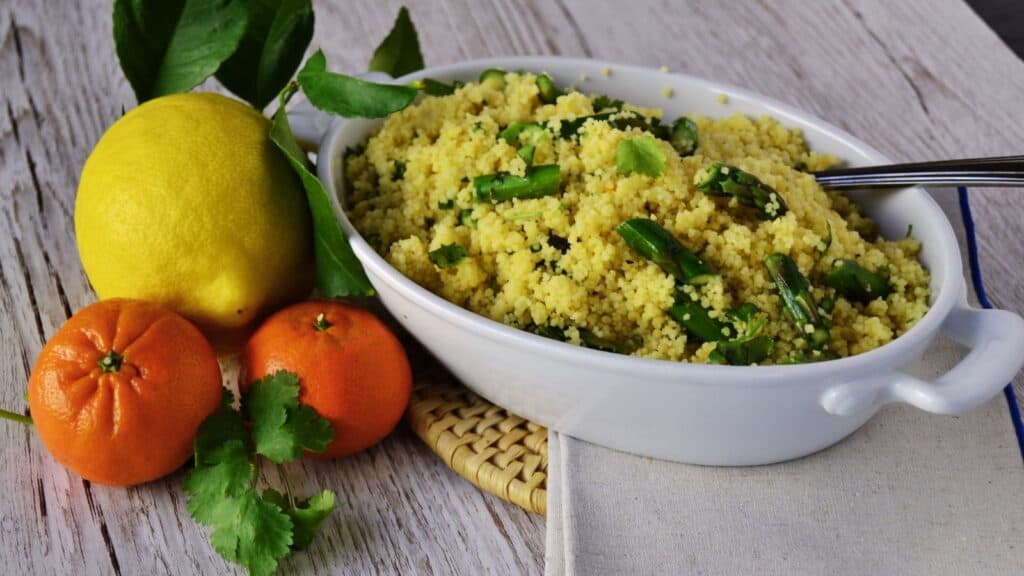 A bowl of citrus couscous with lemons and oranges.