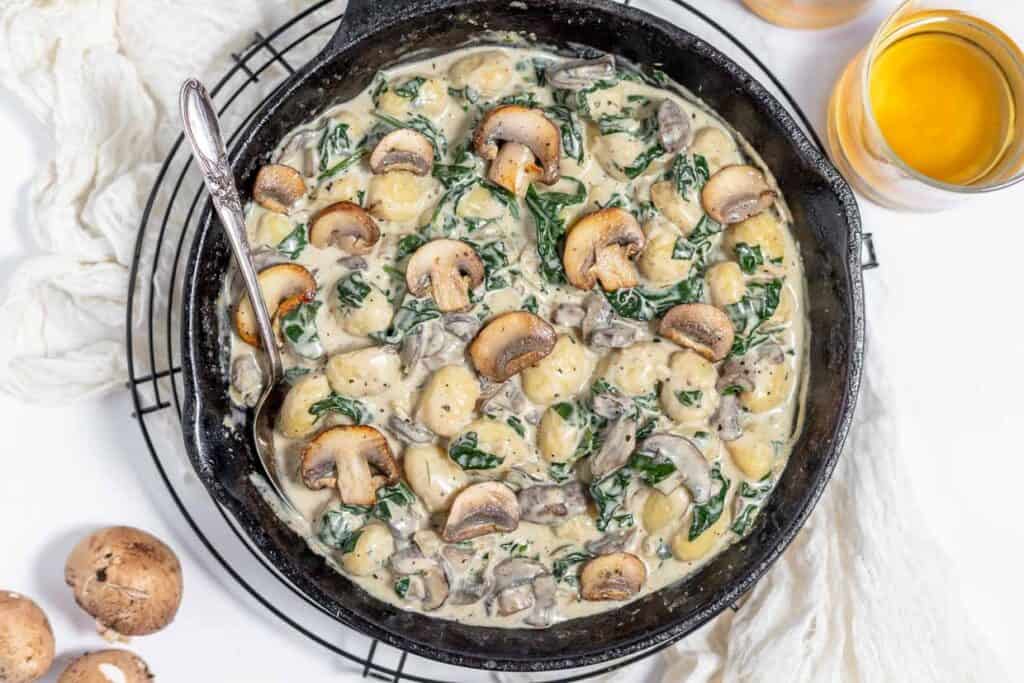 A skillet filled with mushrooms and spinach.
