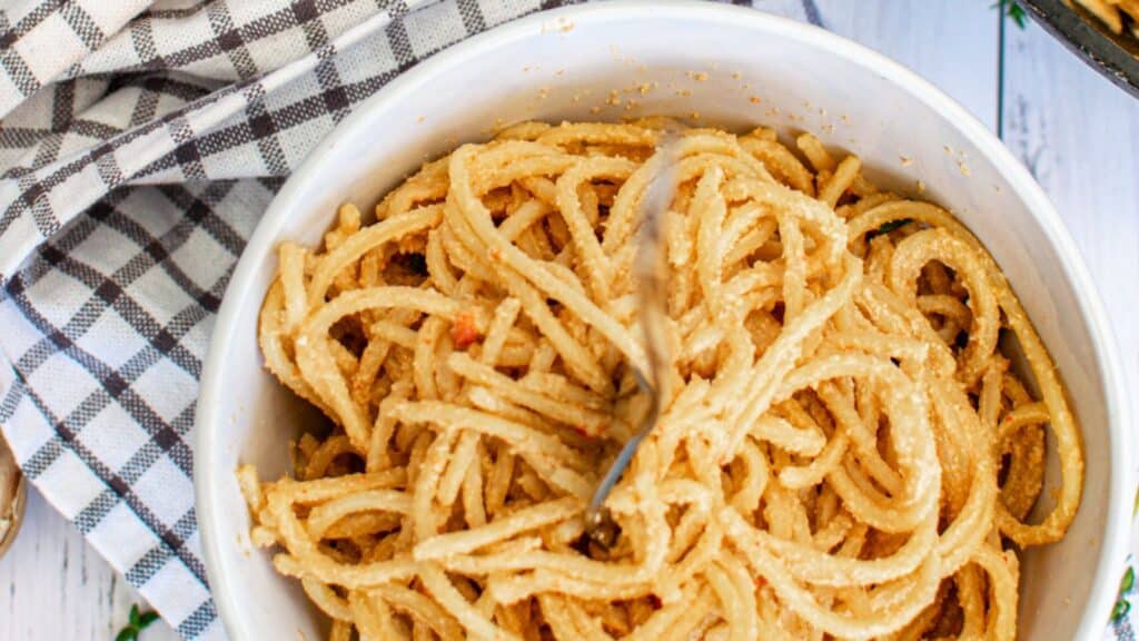 A bowl of pasta with a spoon in it.