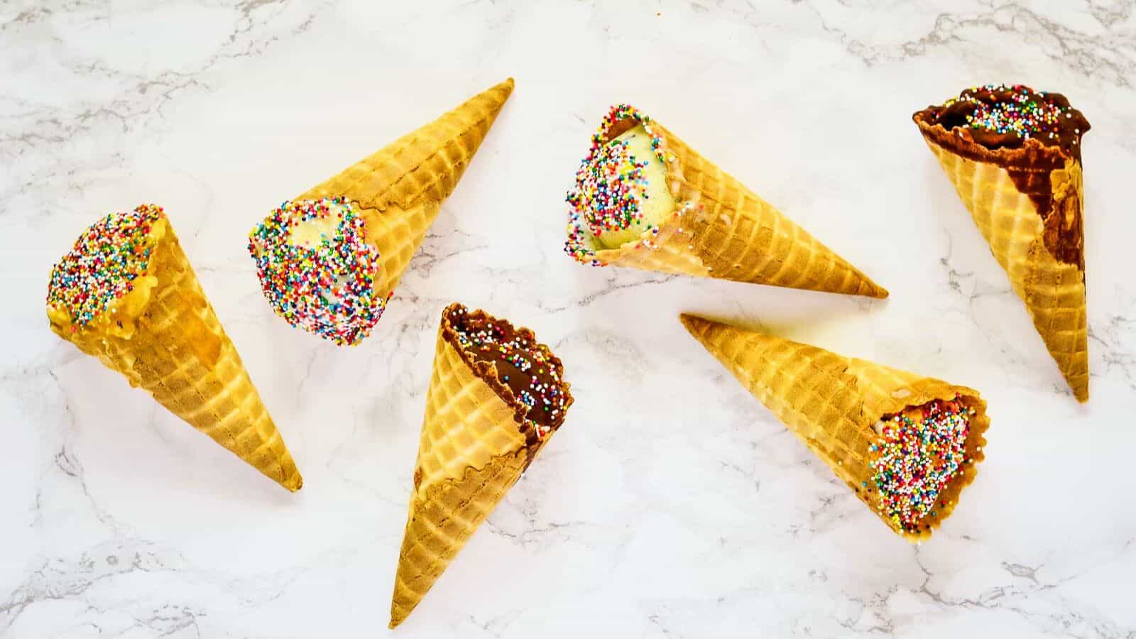 Overhead shot of 6 cones, two in chocolate, two peanut butter, two vanilla.