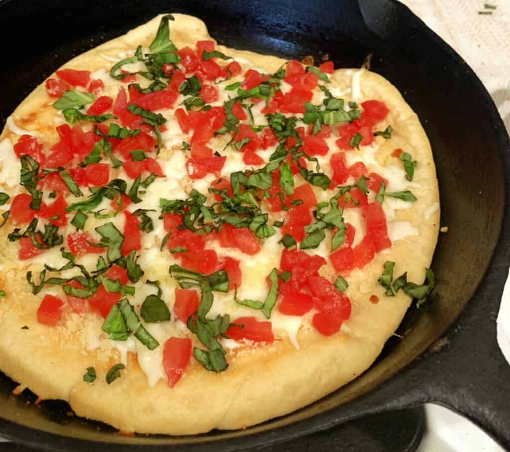 A pizza in a cast iron skillet.