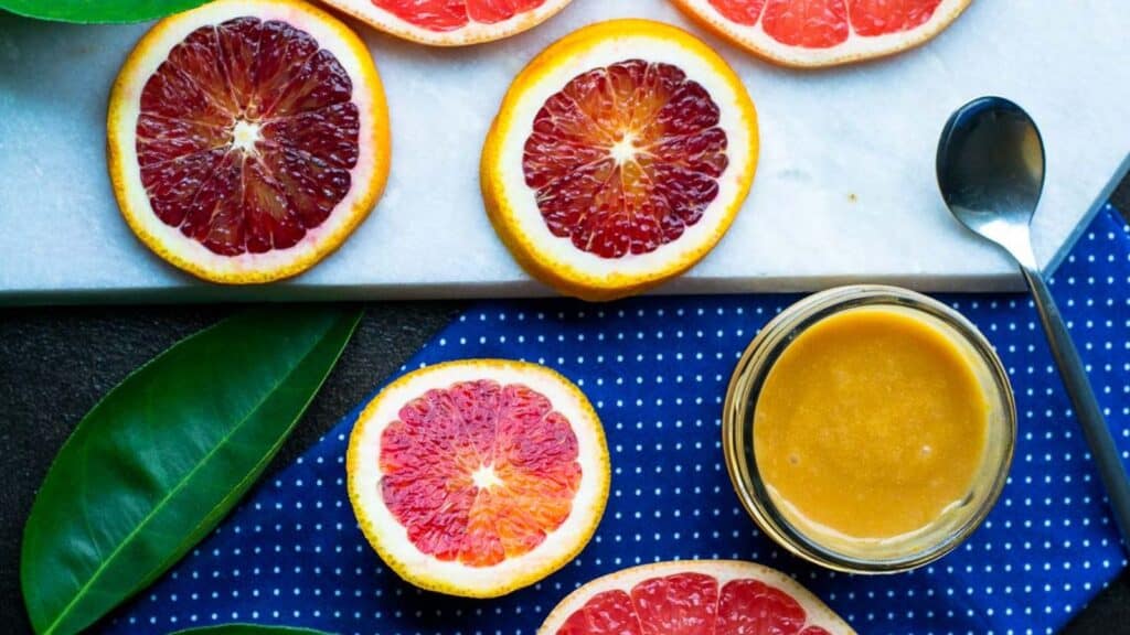 A plate with grapefruit slices and a spoon.