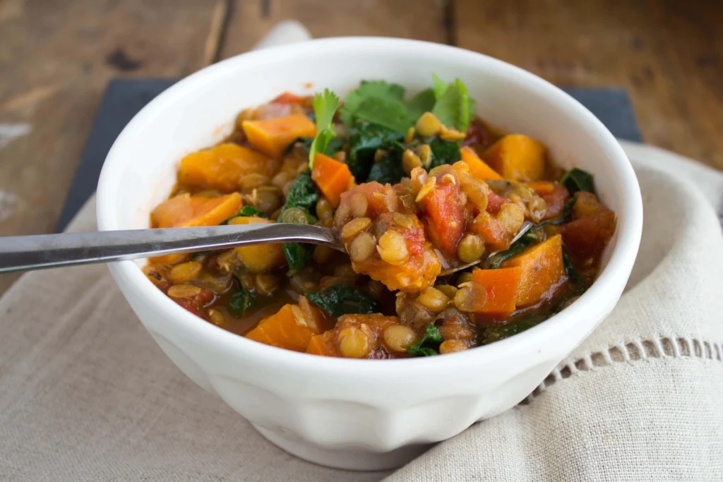 Sweet potato lentil chili topped with cilantro in a white bowl.