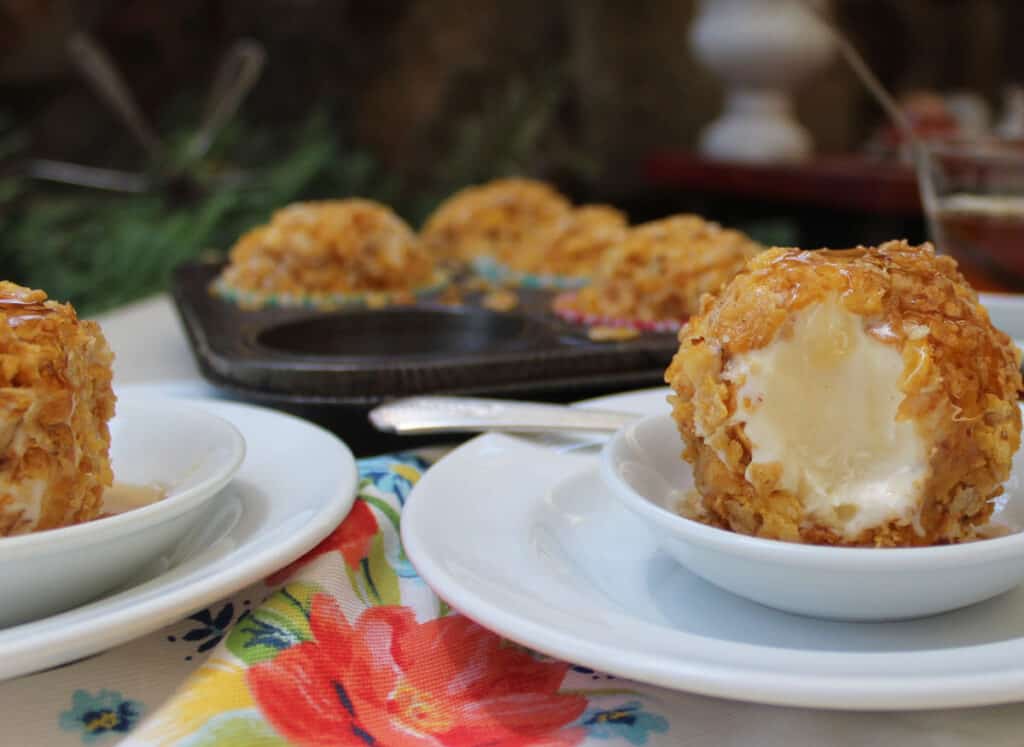 Two plates of no-fried ice cream balls on a table.