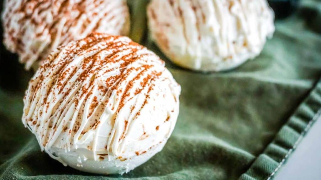 Three ice cream balls on a green napkin with chocolate recipes.