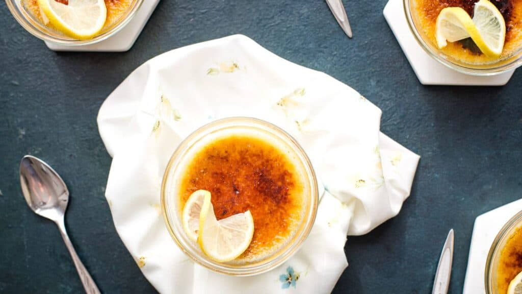 A serving of lemon creme brulee with a lemon garnish. 