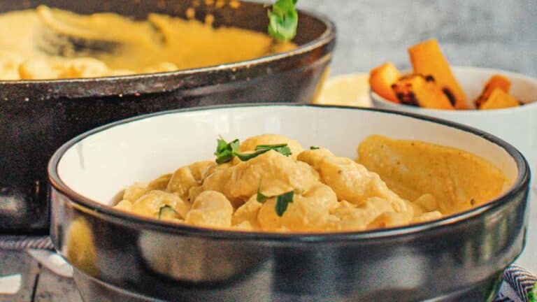 A bowl of macaroni and cheese is sitting on a table.