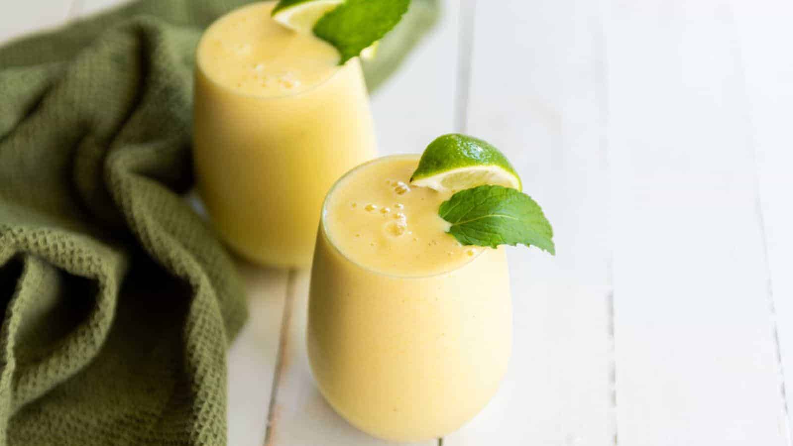 Two glasses with tropical smoothie and limes.