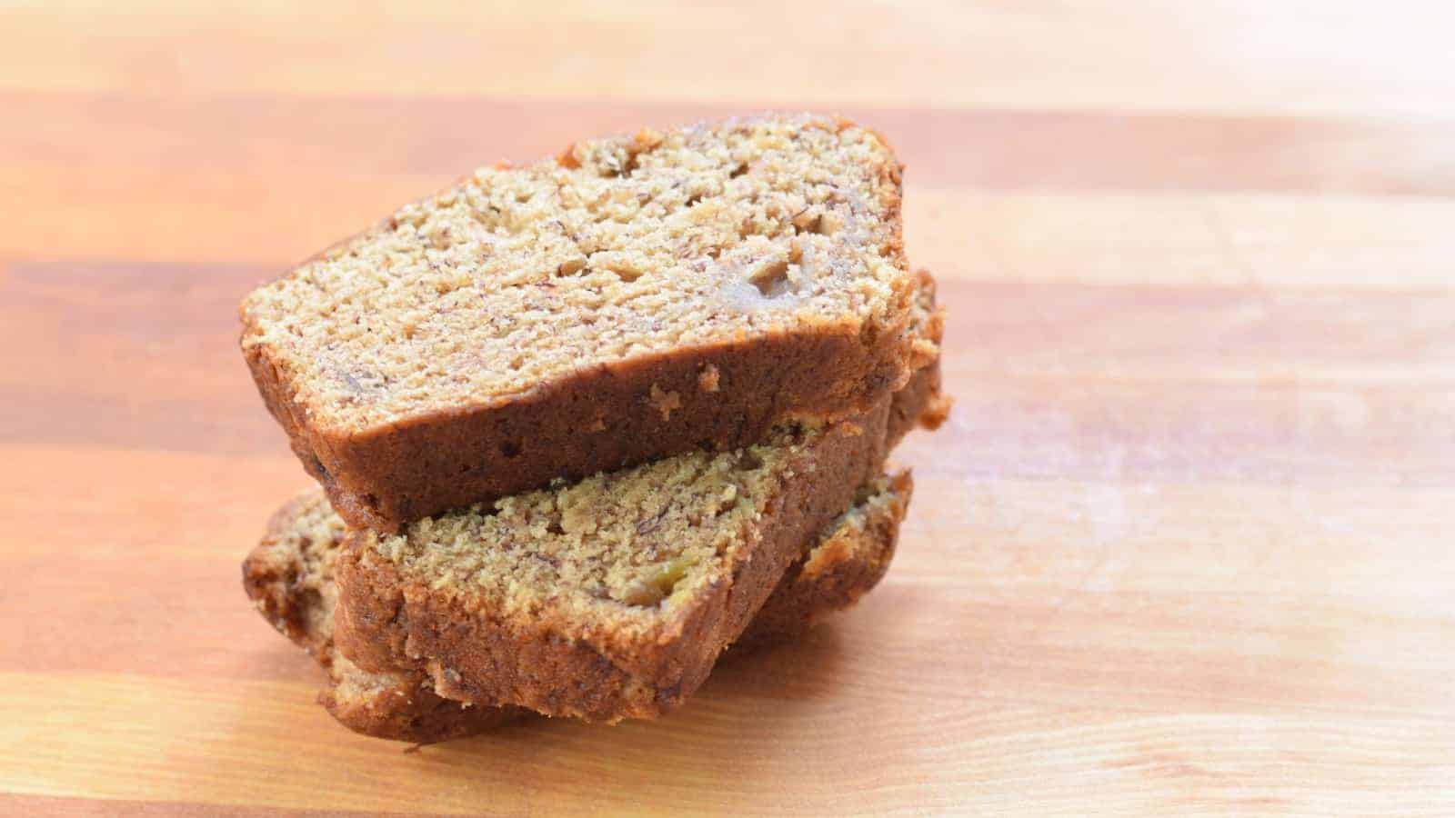 Slices of banana bread stacked on a cutting board.