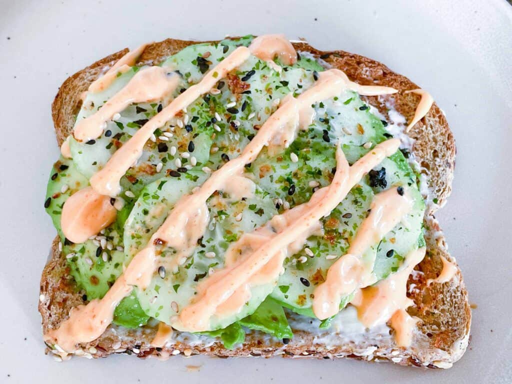 A white plate with a cucumber sandwich on it.