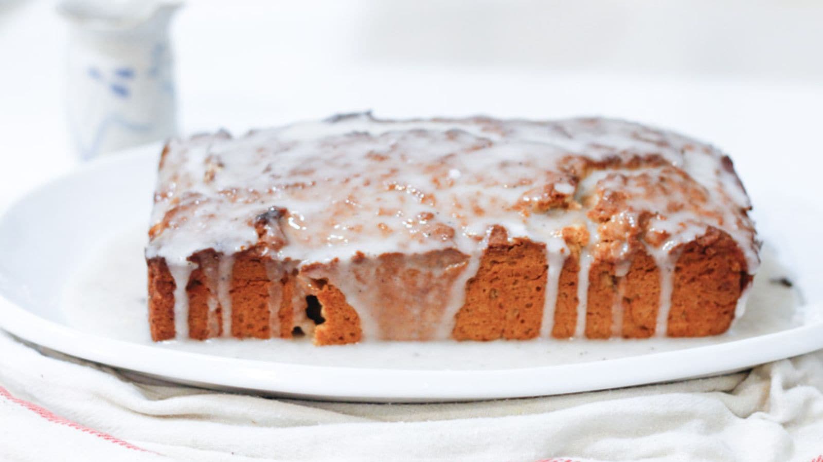 A loaf of bread with icing on a plate.