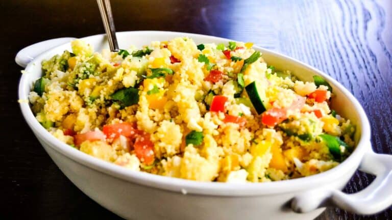 A white bowl filled with couscous and vegetables.