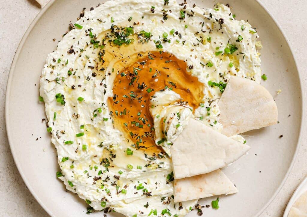 Whipped feta dip and pita bread on a plate.