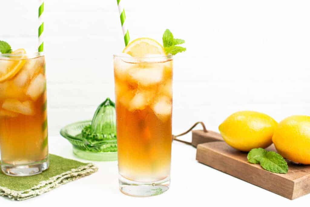 Two glasses of iced tea with lemons and mint.