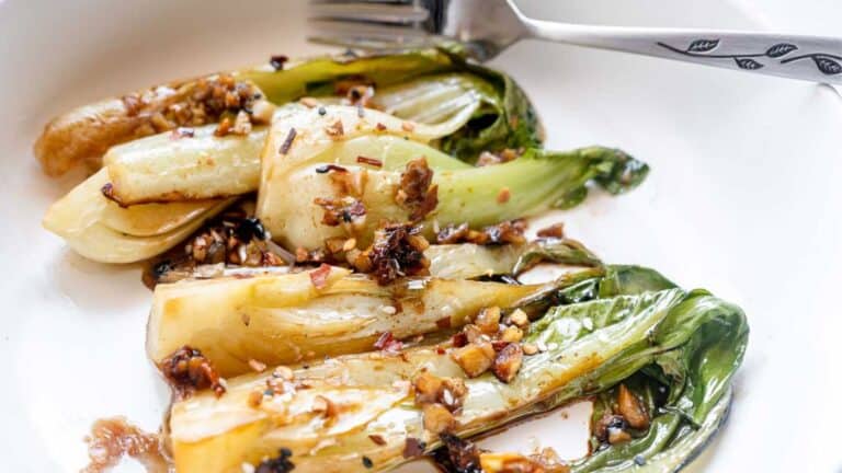 A plate of steamed bok choy, one of the easiest and tastiest lazy veggie side dishes, enjoyed with a fork.