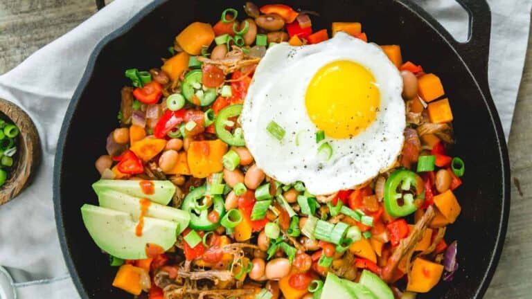 A skillet with a fried egg and vegetables.