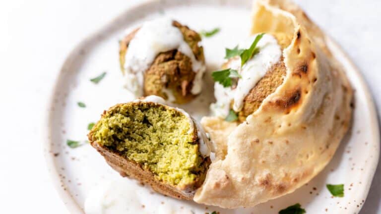 A plate with falafel and pita bread on it.