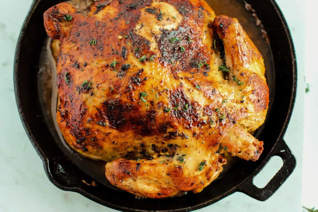 A roasted chicken in a cast iron skillet.