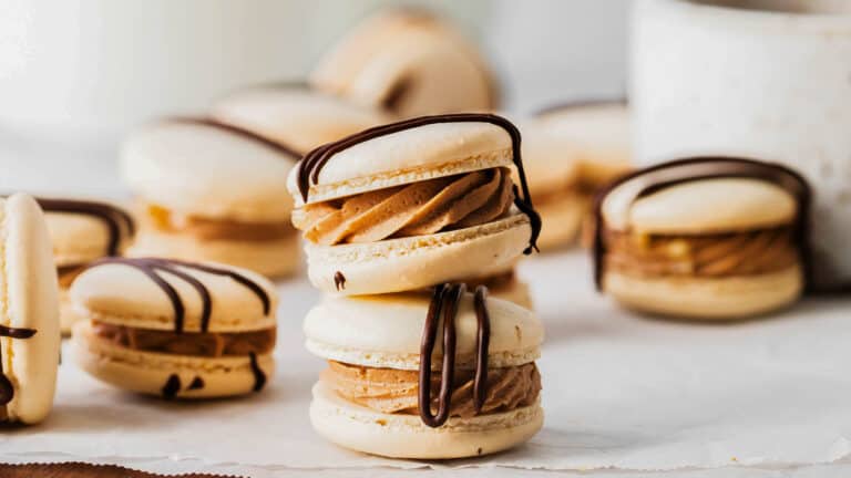 A stack of cookies with chocolate drizzled on top.