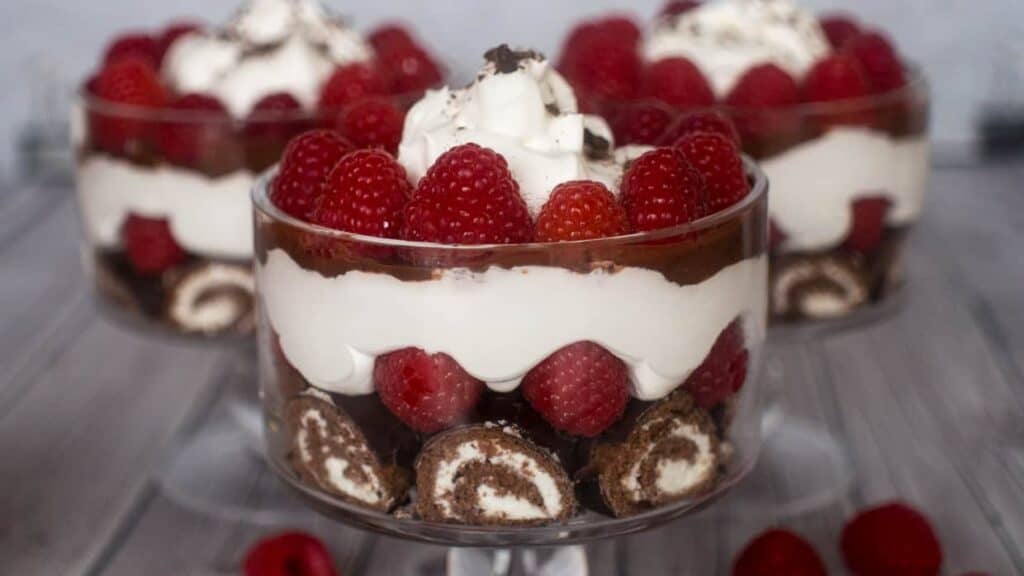 Valentine's trifles that are perfect for lazy bakers, topped with whipped cream and raspberries.