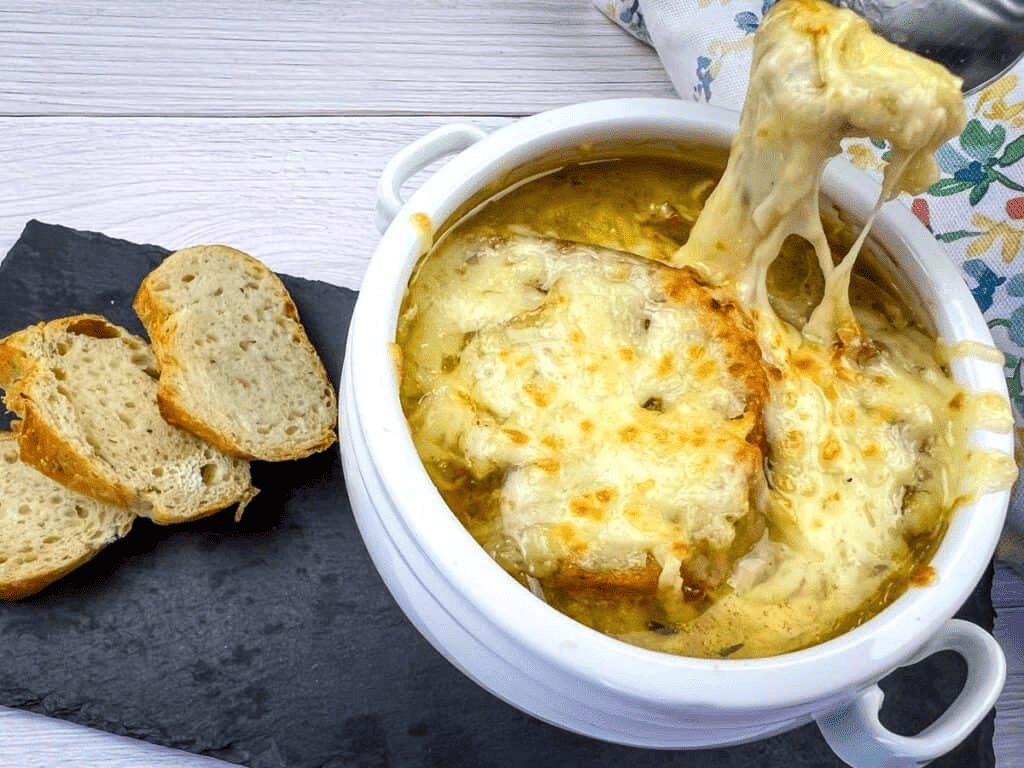 A bowl of French onion soup with bread on top.