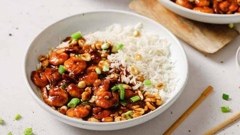 A bowl of shrimp and rice with chopsticks.